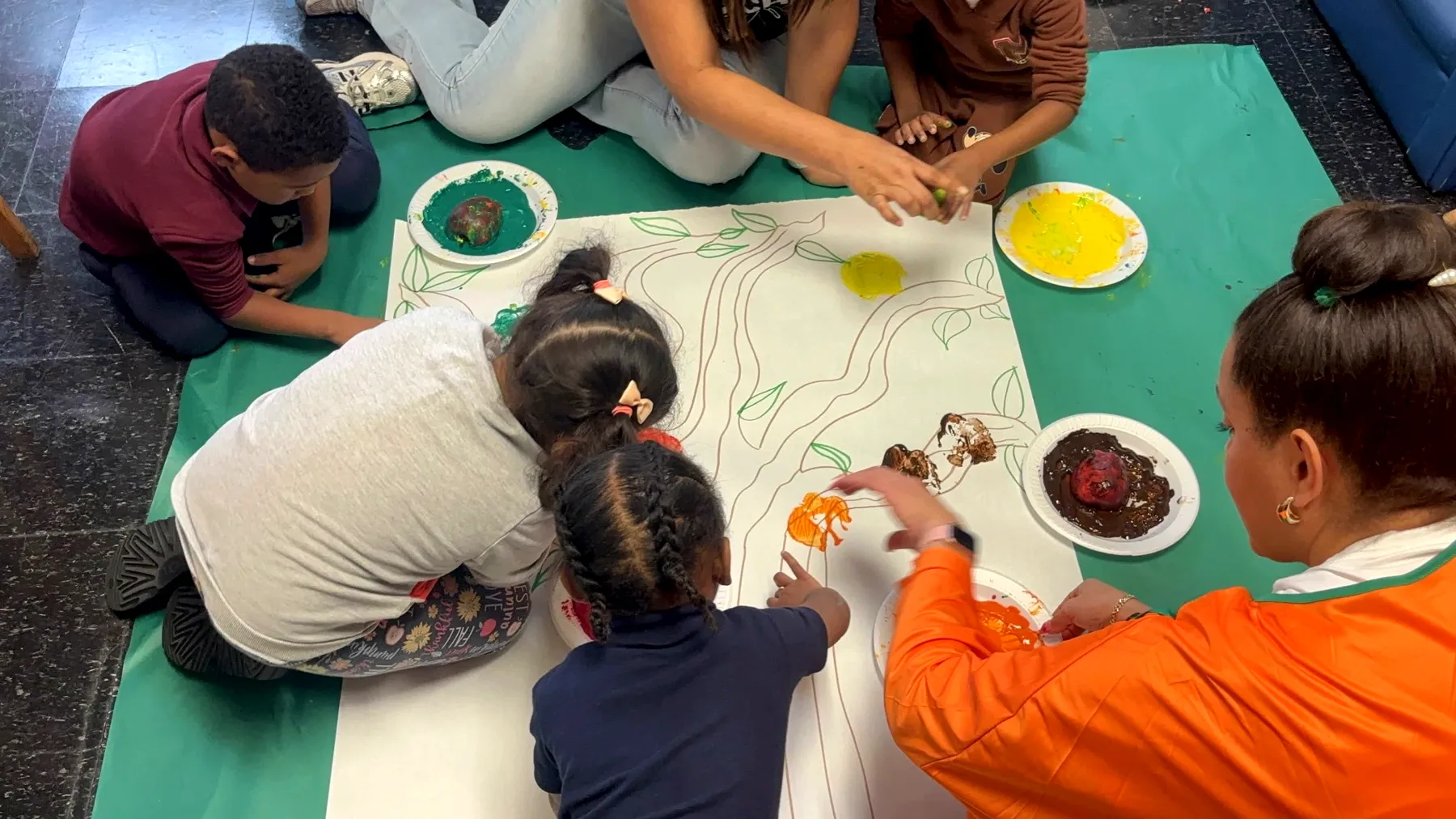 Children and teachers doing a hands-on painting activity at PDC100