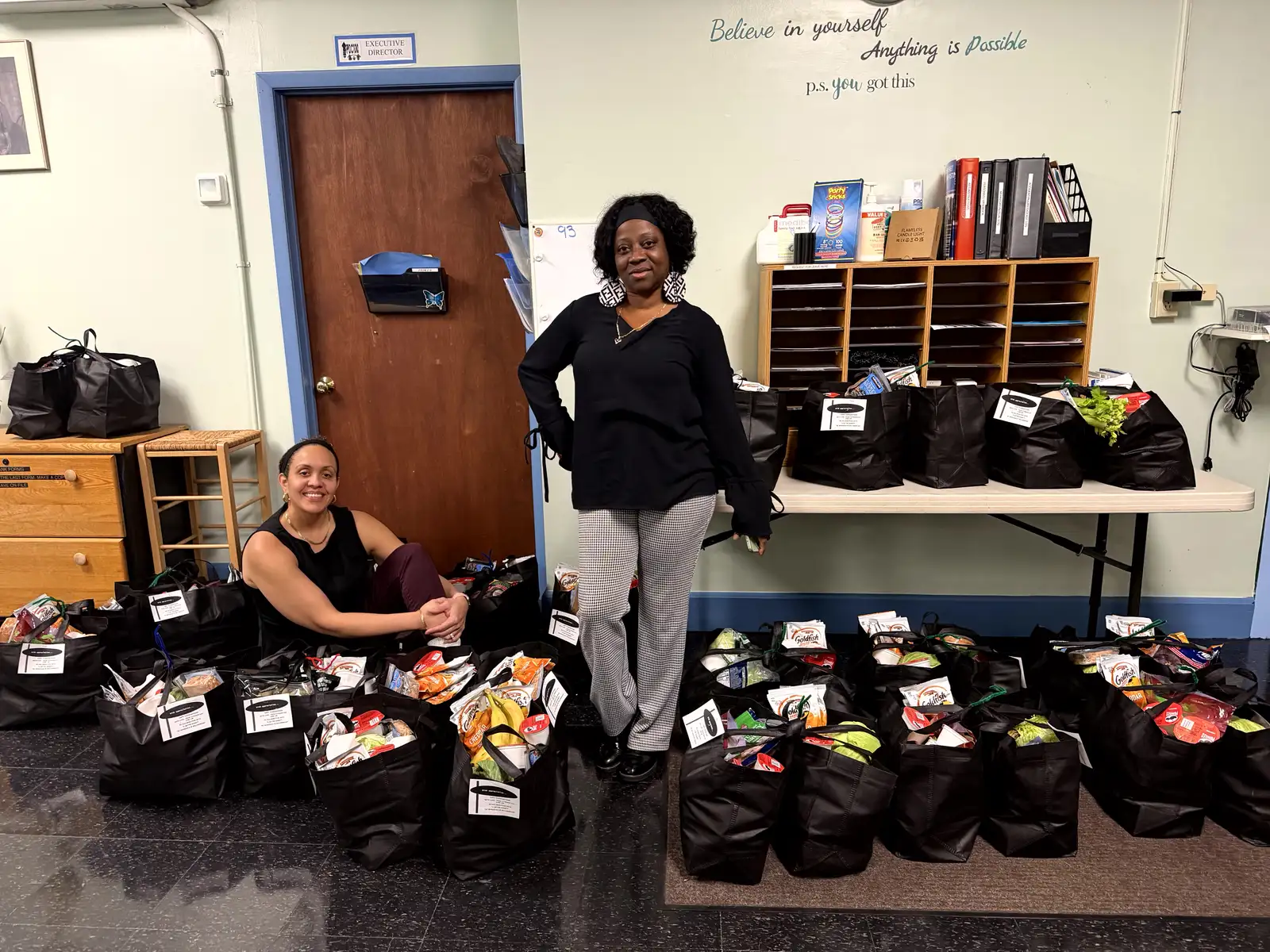 PDC100 staff supporting families with donated food bags
